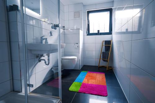 uma casa de banho com um tapete de arco-íris no chão em FeWo WOW! TOP Lage! Schöne 2-Zimmer Wohnung! em Weisweil