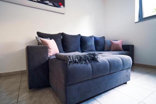 a blue couch with pillows on it in a room at FeWo WOW! TOP Lage! Schöne 2-Zimmer Wohnung! in Weisweil