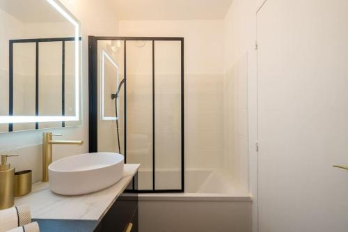 uma casa de banho branca com uma banheira e um lavatório em Appartement Cosy Art Déco/ Proche centre-ville em Nantes