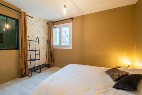 - une chambre avec un grand lit blanc et une fenêtre dans l'établissement Appartement Cosy Art Déco/ Proche centre-ville, à Nantes