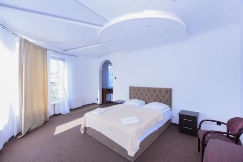 a bedroom with a large bed and a large window at Hotel Continent in Polyana