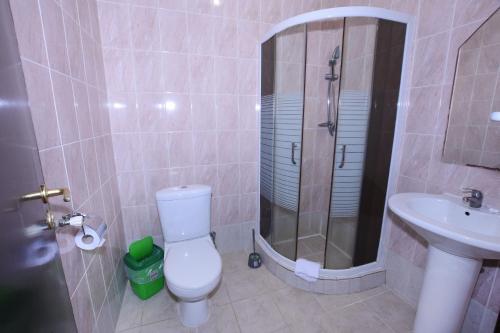 a bathroom with a shower and a toilet and a sink at Hotel Continent in Polyana