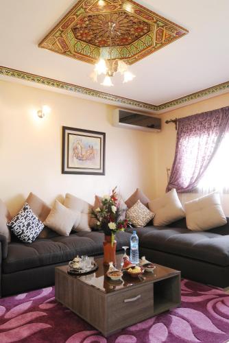 a living room with a couch and a coffee table at Aparthotel Les Oliviers Suites & Spa in Fès