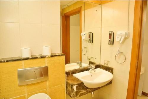 a bathroom with a sink and a toilet and a mirror at Royal Marina Inn in Dubai