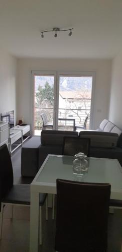 sala de estar con sofás, mesa y ventana en modern appartament en Porlezza