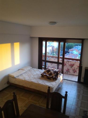 1 dormitorio con cama y ventana grande en Departamento Monoambiente grande a 9 cuadras del mar. Mar del plata. Para 4 personas. Impecable Estado. Balcón Amplio. Luminoso. Excelente zona. en Mar del Plata