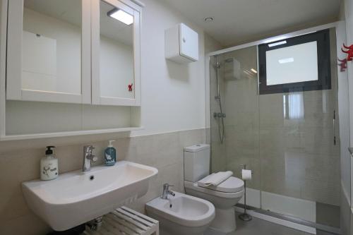 uma casa de banho com um lavatório, um WC e uma televisão em Enjoy La Reserva El Rompido em El Rompido