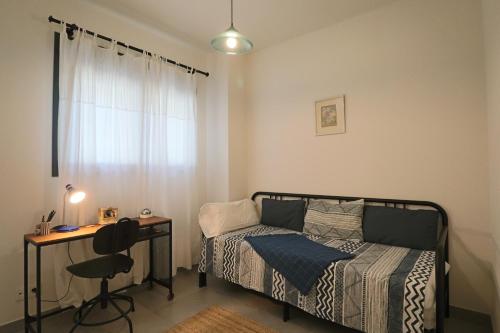 1 dormitorio con cama, escritorio y ventana en Enjoy La Reserva El Rompido, en El Rompido