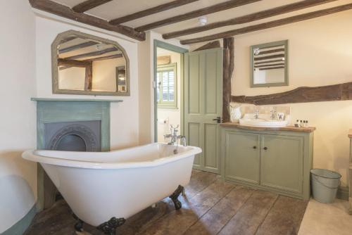 a bathroom with a white bath tub and a fireplace at The Standard Inn in Rye