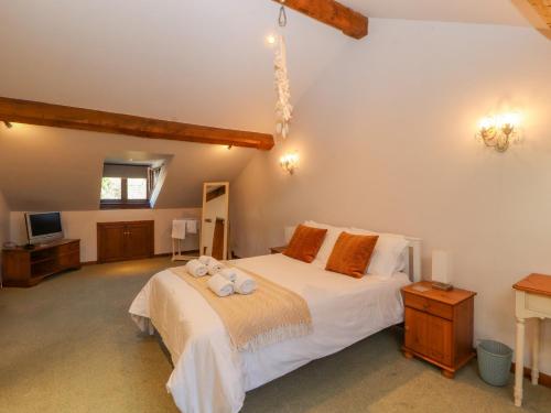 a bedroom with a large bed with towels on it at Clerk Beck Cottage in Ulverston