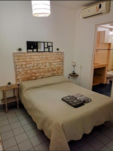 1 dormitorio con cama y pared de ladrillo en Gladiadores en Salta