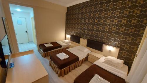 a small room with two beds and a mirror at Selimpaşa Borsa İstanbul MTAL Uygulama Oteli in Silivri
