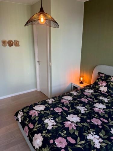 a bedroom with a bed with a floral comforter at "VH apartment" - center of Antwerp - free parking in Antwerp