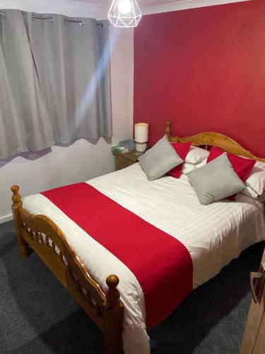 a bedroom with a bed with a red and white blanket at Southway Double Room near Derriford in Plymouth