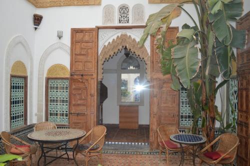 una habitación con mesas, sillas y una planta en Riad Kasbah en Rabat