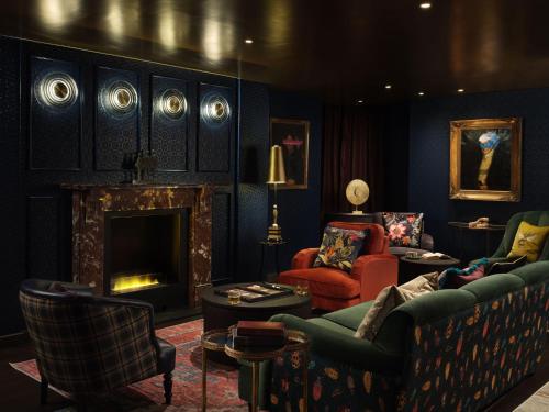 a living room with a couch and a fireplace at The Other House South Kensington in London
