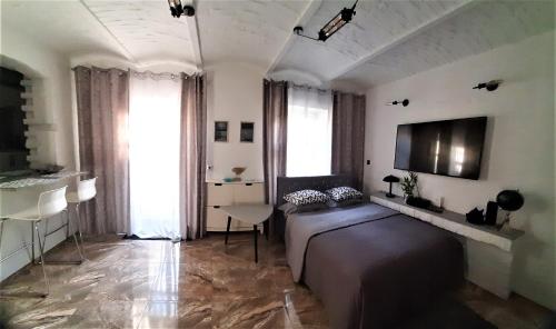 1 dormitorio con 1 cama y TV en la pared en Studio Four - prywatne wejście i taras w Centrum Sopotu, en Sopot
