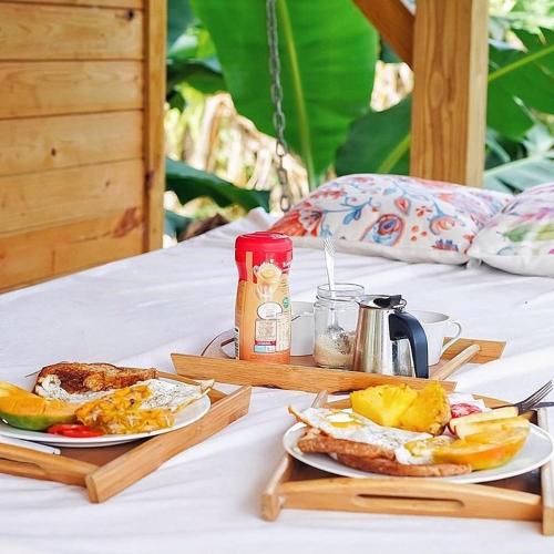 Una mesa de desayuno con dos platos de huevos y tostadas. en Samana Ecolodge, en El Limón