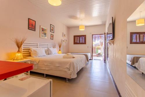 a bedroom with a large bed and a red table at Pousada La Vie Jeri in Jericoacoara