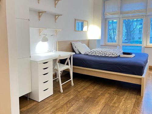 um pequeno quarto com uma cama, uma secretária e uma mesa em Dom KD KRUK em Lódź