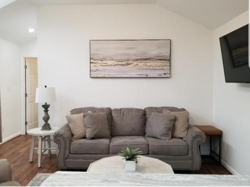 Tiny home rentals near Ft Moore في فينيكس سيتي: غرفة معيشة مع أريكة ولوحة على الحائط