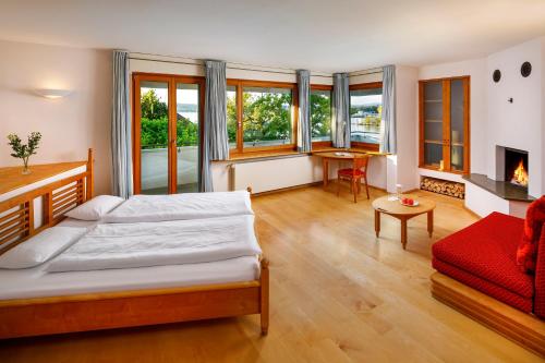 a bedroom with a bed and a living room at Hotel Restaurant Schiff in Pfäffikon