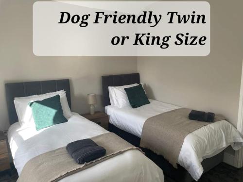 two beds in a room with a dog friendly twin or king size at The Black Horse Inn in Settle