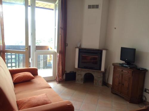 ein Wohnzimmer mit einem Sofa und einem TV in der Unterkunft Appartamento Stalle Lunghe in Prato Nevoso