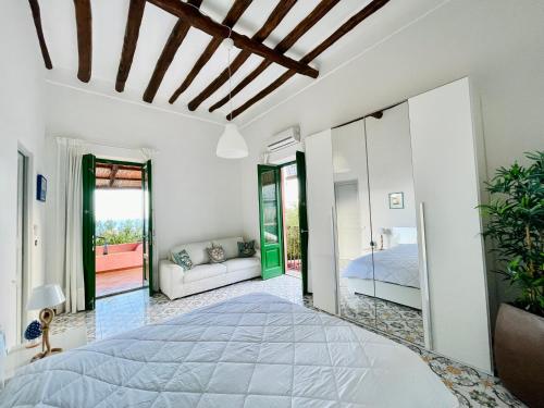 1 dormitorio con 1 cama y 1 sofá en una habitación en Villa Pomelia, Villa nel corso di Santa Marina Salina a 50 mt dal mare, en Santa Marina Salina