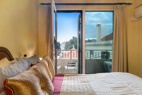 1 dormitorio con cama y vistas a un balcón en Palheiro Residence Vista Mar, en Funchal