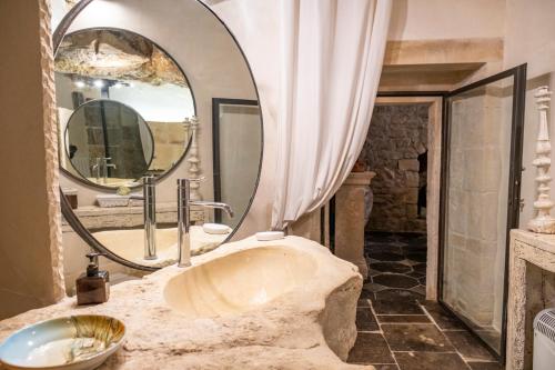 a bathroom with a sink and a large mirror at San Giorgio Palace Modica in Modica