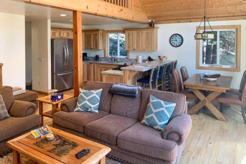 a living room with two couches and a kitchen at Rustic Retreat with Deck Steps From Lake Almanor! in Lake Almanor