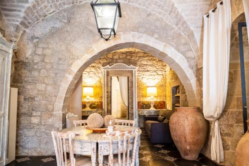 Cette chambre dispose d'une table et d'un mur en pierre. dans l'établissement Modica Luxury Palace, à Modica