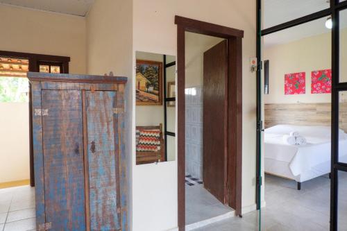 una camera con un letto e una porta in vetro di Recanto das Abelhas - 300 m do centro histórico a Tiradentes