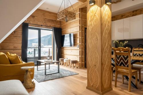 una sala de estar con paredes de madera y una escalera. en STACJA NOSAL Apartamenty, en Zakopane