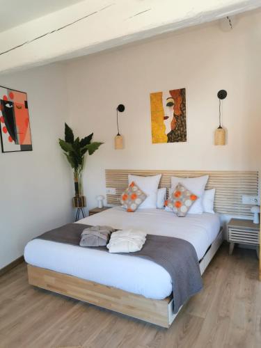 1 dormitorio con 1 cama blanca grande con almohadas en Arles Holiday - Le Refuge, en Arles