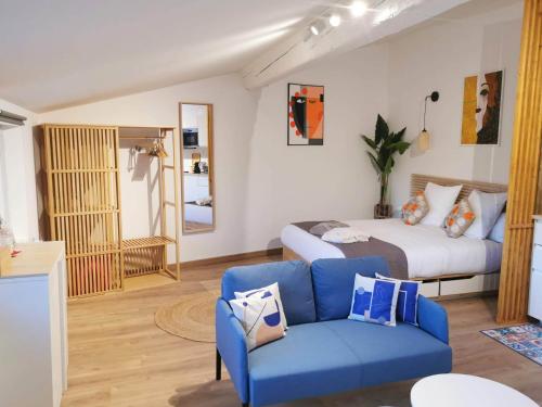 sypialnia z łóżkiem i niebieską kanapą w obiekcie Arles Holiday - Le Refuge w mieście Arles