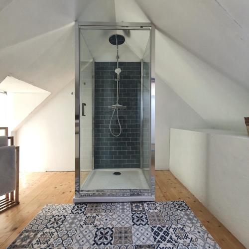a glass shower in a room with a tile floor at FORET TOTEM - Hébergements nature et bien-être en pleine forêt in Persquen