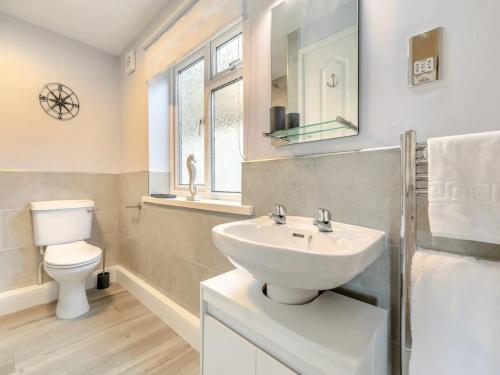 a white bathroom with a sink and a toilet at Lobster Pot - Mount Brioni in Downderry