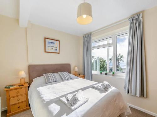 a bedroom with a large bed and a window at Apartment 2 - Mount Brioni in Downderry