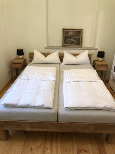 two beds with white sheets on them in a room at Ferienwohnung "Altes Schloss Wilhelmsfeld" 