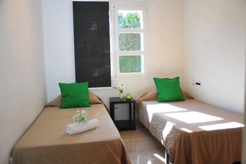2 camas en una habitación con almohadas verdes en VILLA ALFABIA en Palma de Mallorca