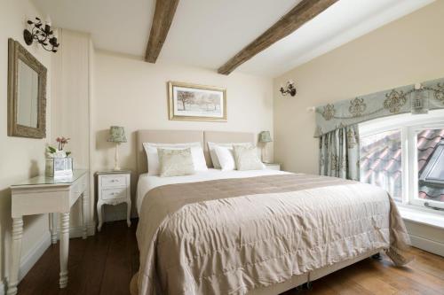 um quarto com uma cama grande e uma janela em The Dovecote em York