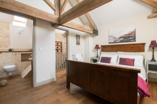 a bedroom with a large bed and a bathroom at The Dovecote in York