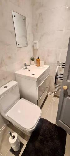 a white bathroom with a toilet and a sink at New Build Cosy Duplex Modern Apartment Greater Manchester in Stockport