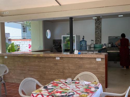 a restaurant with a table and chairs and a kitchen at Hotel Kemarios in Tonsupa