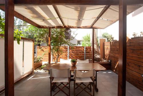 patio con tavolo in legno e sedie sotto tenda di Euzoia luxury maisonette a Chania