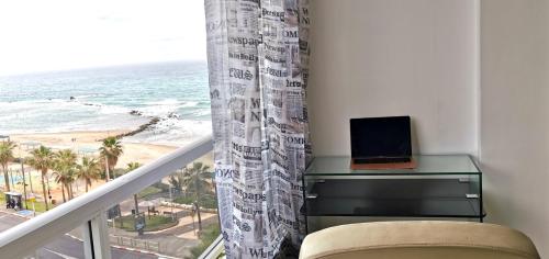 a room with a balcony with a laptop on a desk at Large apartment with sea view in Bat Yam