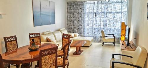 a living room with a table and chairs at Large apartment with sea view in Bat Yam