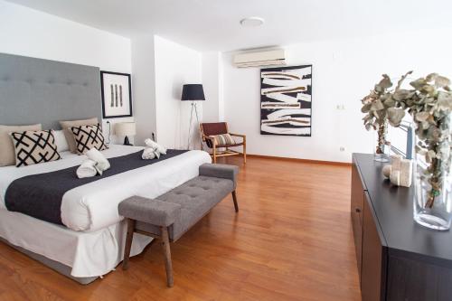 a bedroom with a large bed and a chair at Loft Valterna 9 in Paterna